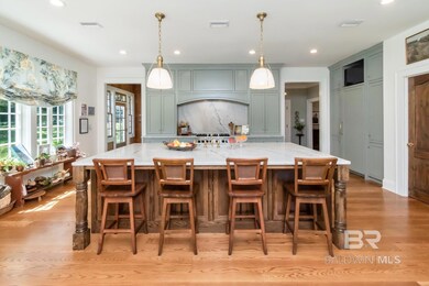 Kitchen with recessed lighting, light wood-style flooring, pendant lighting, light stone counters, and a kitchen bar