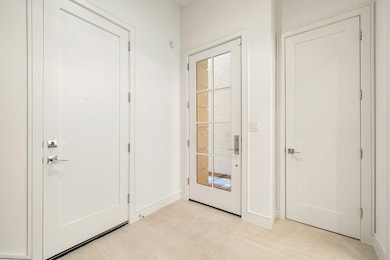 This entryway features a modern door with glass pa