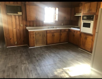 Kitchen with dark wood-style floors, light counter