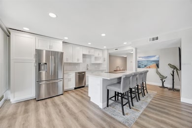 Enter into your open modern kitchen that with stainless appliances and room for 4 at the island.