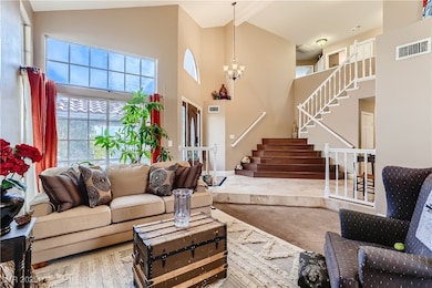 Living area featuring a high ceiling, stairway, an