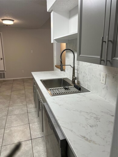 Kitchen featuring dishwasher, open shelves, a sin
