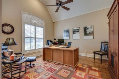 French doors off the entryway lead to the Office, with wood floors, arched ceiling, crown molding and plantation shutters on the Palladian windows.  