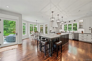 Dining space featuring sink, a healthy amount of sunlight, a chandelier, and dark wood-type flooring
