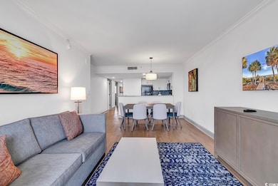 Living room featuring crown molding, light wood-st