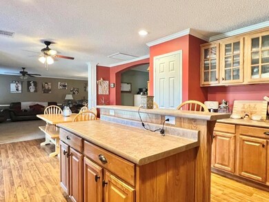 Kitchen with a textured ceiling, a kitchen island,