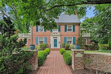 Colonial home with brick siding and a shingled roo