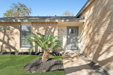 INVITING FRONT ENTRYWAY WITH A BRICK VENEER AND FRESH LANDSCAPING.