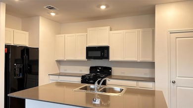Kitchen featuring black appliances, a sink, white