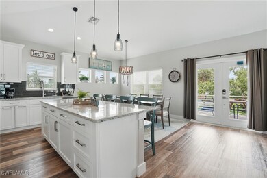 Kitchen with a breakfast bar, plenty of natural light, a center island, wood finished floors, and recessed lighting