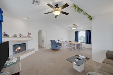 Carpeted living area featuring lofted ceiling, a c
