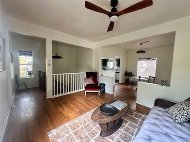Living area featuring wood finished floors, healthy amount of natural light, and ceiling fan