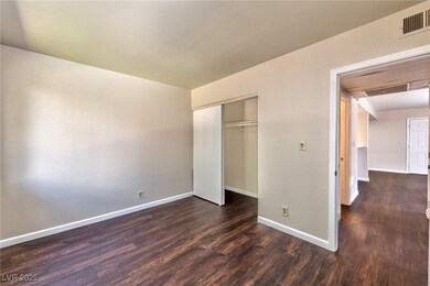 Unfurnished bedroom with wood finished floors, bas