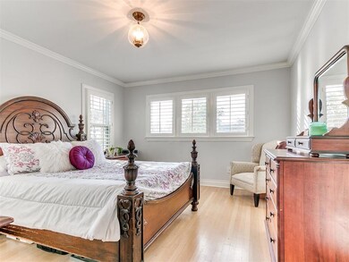 Bedroom featuring multiple windows, light wood-type flooring, and crown molding