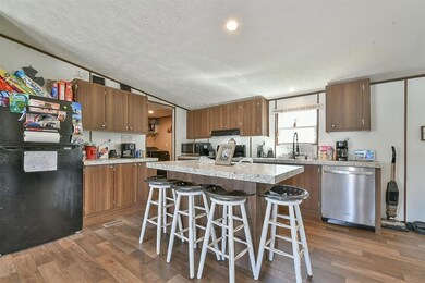 Kitchen with a textured ceiling, dark wood finishe