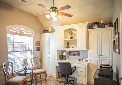 Office area with lofted ceiling, light wood-style flooring, a ceiling fan, and built in study area