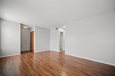 Unfurnished room featuring dark wood-type flooring and baseboards