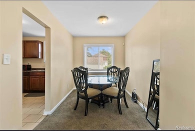 Dining space featuring dark carpet and dark tile patterned floors