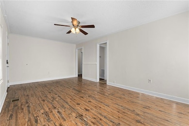 Unfurnished room with dark wood-style floors, a textured ceiling, and a ceiling fan