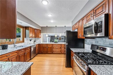 Impressive kitchen with cherry soft close cabinets and granite countertops with pendant and recessed lighting.