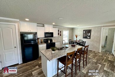 kitchen featuring a textured ceiling, black appliances, dark wood-type flooring, ornamental molding, and white cabinetry