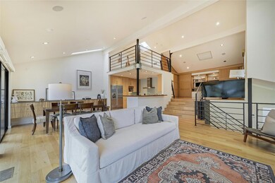 Living room with high vaulted ceiling, light wood