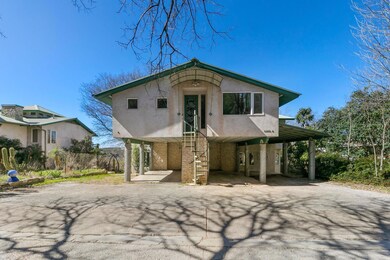View of front of home featuring stairs, a carport, driveway, and stucco siding