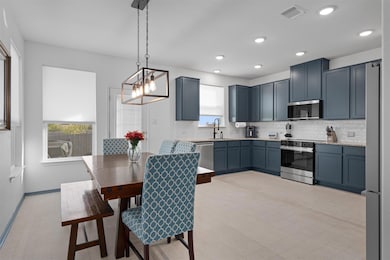 Kitchen with healthy amount of natural light, backsplash, light floors, and recessed lighting