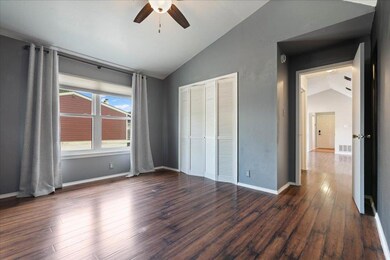 Unfurnished bedroom with vaulted ceiling, wood fi