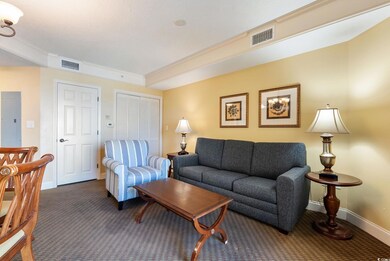 Living room featuring crown molding and dark carpe