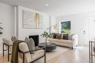 Living area with light wood-style flooring, recessed lighting, and a fireplace