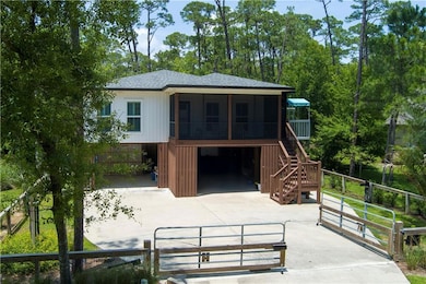 Back of house with concrete driveway, a sunroom, a shingled roof, stairway, and an attached garage