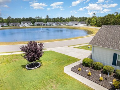 View of pool featuring a lawn, a water view, and a