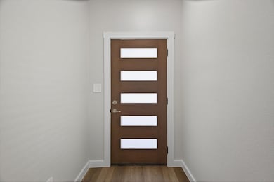 Entryway with wood finished floors and baseboards