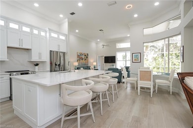 Kitchen with an island with sink, ceiling fan, sta