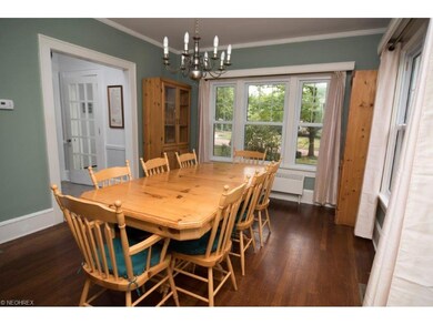 Formal dining room with wood flooring, crown moldi