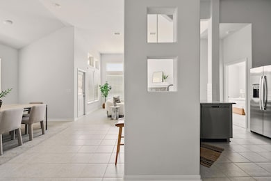 Hall featuring high vaulted ceiling, light tile p