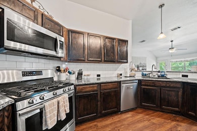 Kitchen with stainless steel appliances, dark woo