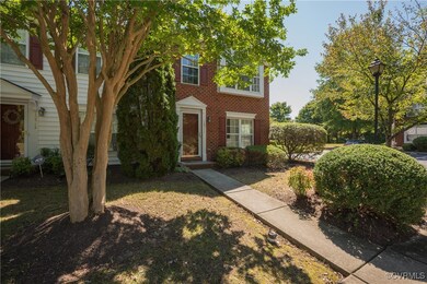 View of townhome with brick and an end unit