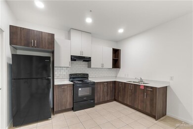 Kitchen with open shelves, black appliances, light countertops, white cabinets, and tasteful backsplash