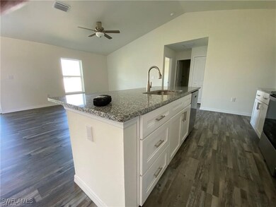 Kitchen featuring white cabinets, dishwasher, dark