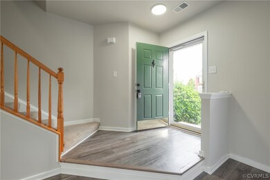 Foyer entrance featuring new flooring and a coat c
