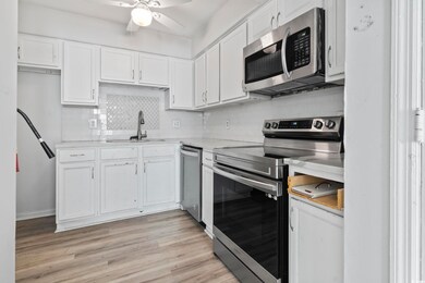Kitchen featuring white cabinets, stainless steel 