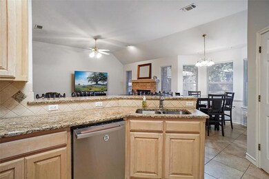 Kitchen with sink, a brick fireplace, lofted ceili