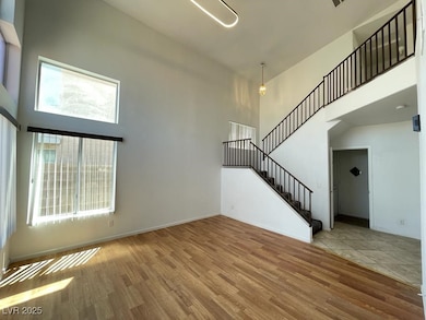 Unfurnished living room with stairway, a high ceil