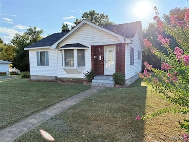 Bungalow-style home with a front lawn and roof with shingles