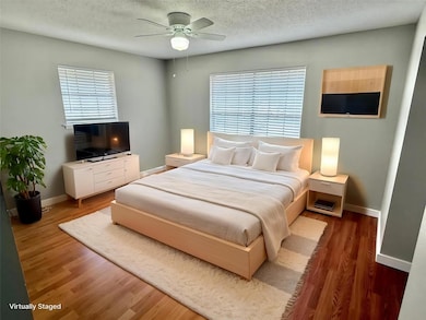 Bedroom featuring baseboards, ceiling fan, a text
