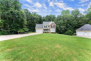 Colonial-style house featuring a front lawn and a garage