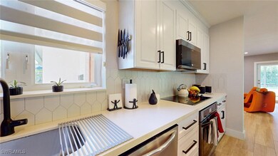 Kitchen with black electric cooktop, oven, tastefu