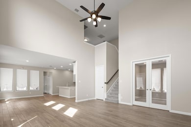 Unfurnished living room featuring french doors, li